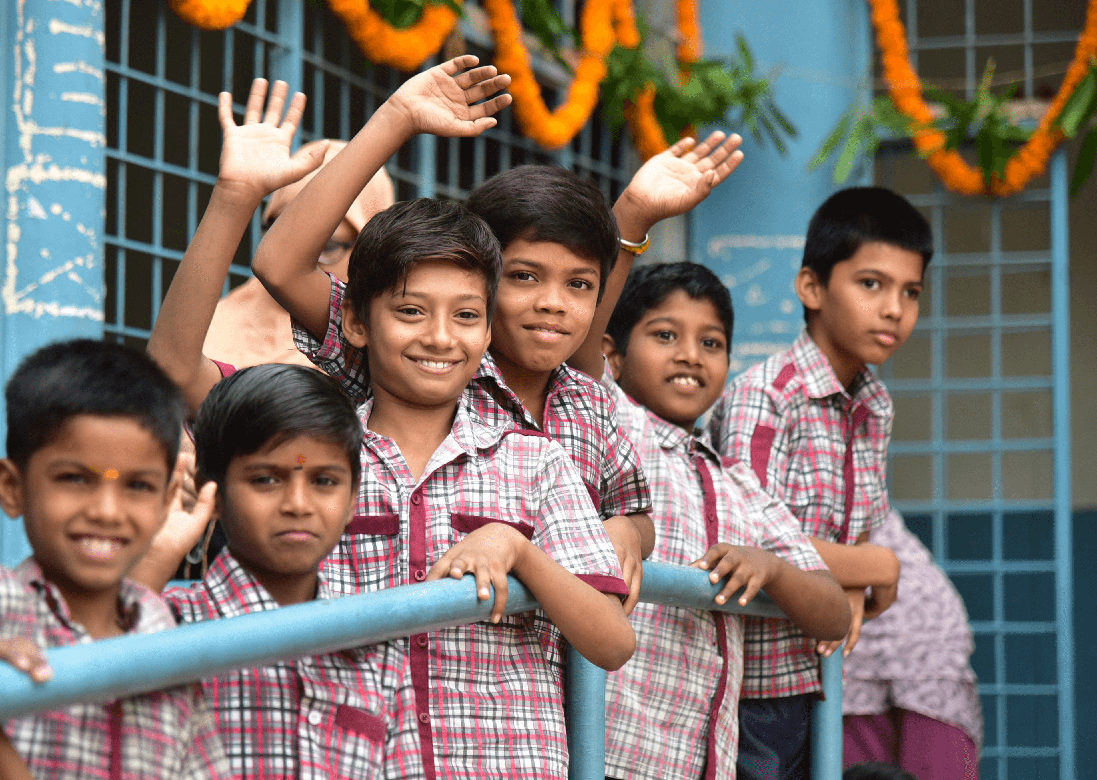 School children smiling and waving